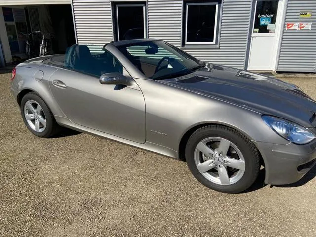 Een Mercedes-Benz SLK op het erf van Auto Moos