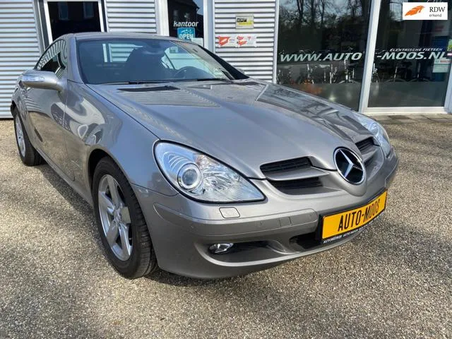 Grijze Mercedes-Benz SLK cabrio voor de winkelpui van Auto Moos in Holtum
