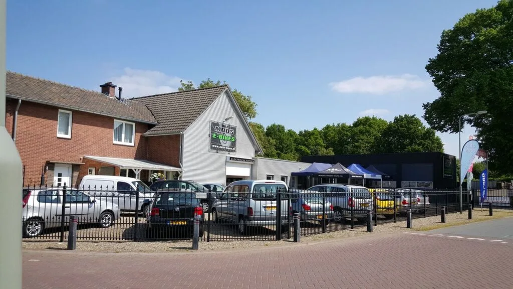 Het pand van Auto Moos aan de Kleine Dries in Holtum, met het bord van Moos E-Bikes en het autoterrein