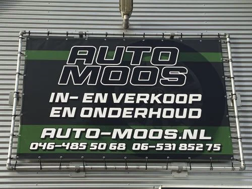 Het gevelspandoek van Auto Moos aan de Kleine Dries